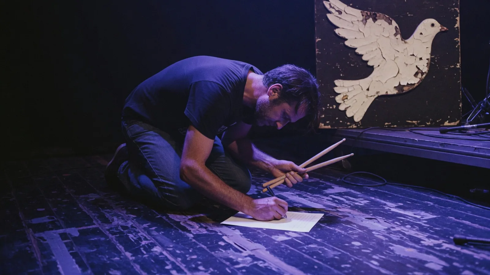 Drummer writing a setlist on stage